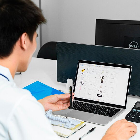 a male worker is managing and analyzing material suppliers with organized excel showed on the laptop screen
